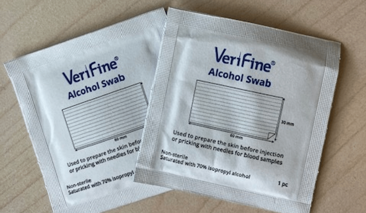 Två paket med alkoholservetter som står på ett träbord.