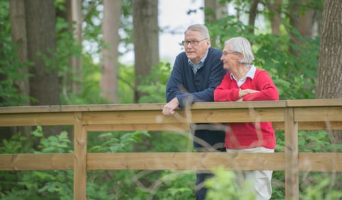 En man och en kvinna står på en träbro.