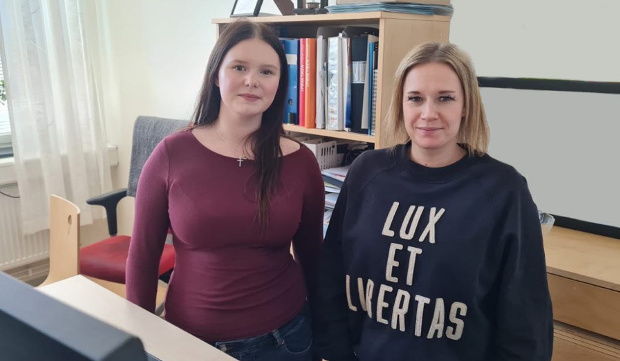 Studie- och yrkesvägledare Julia Wennbergen och hennes elev Tuva Kjellén Strandberg ståendes vid en dator inne på ett kontor