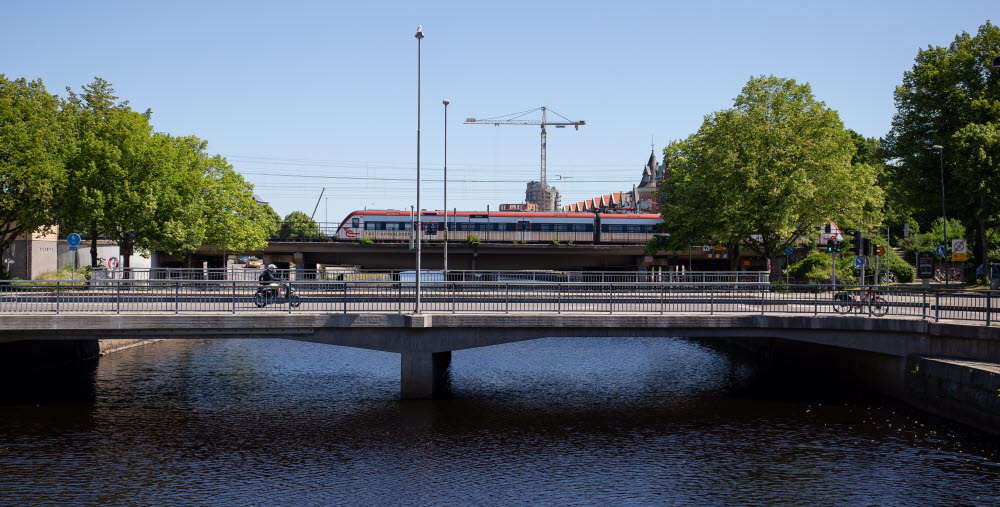 Tåg och bilbro över vattendrag