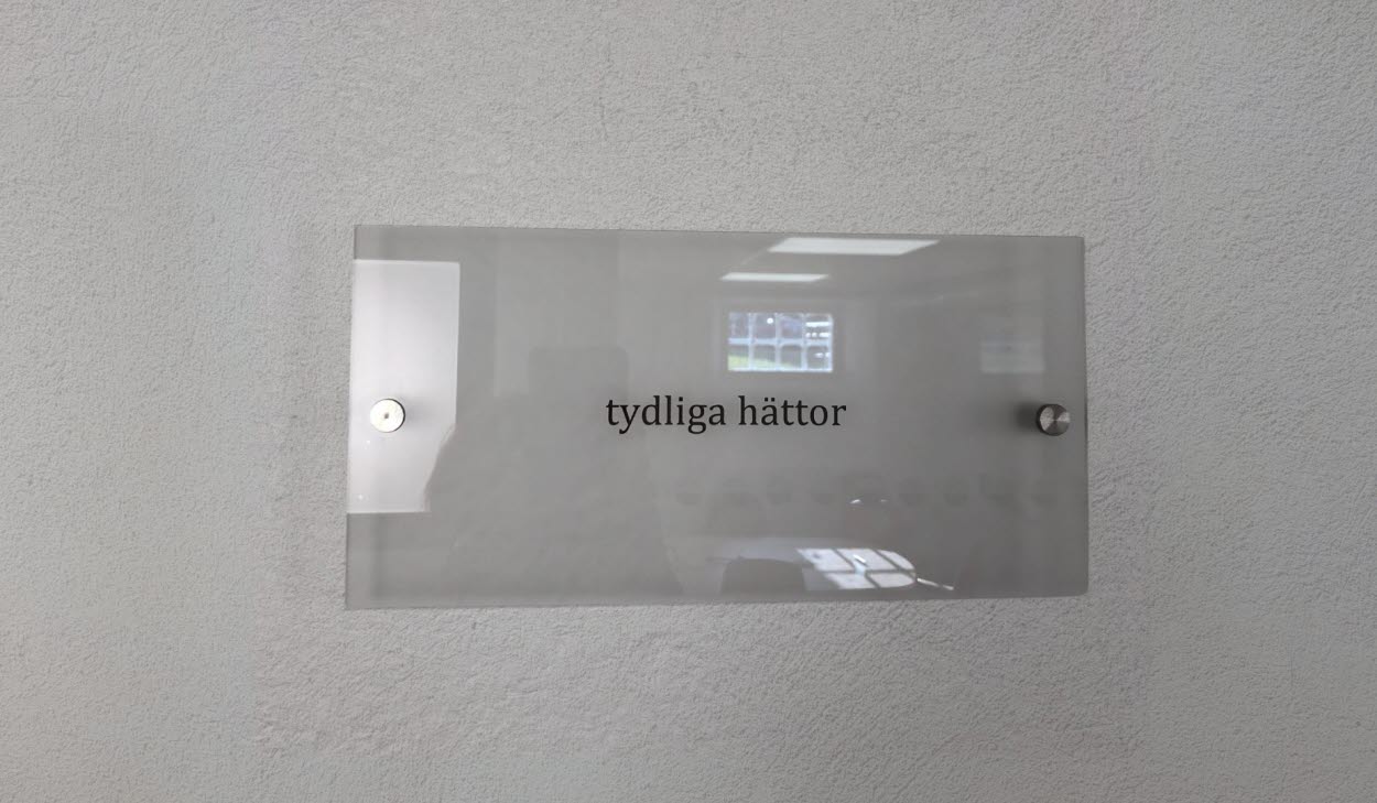 Etsning av text på glas med texten "tydliga hättor".