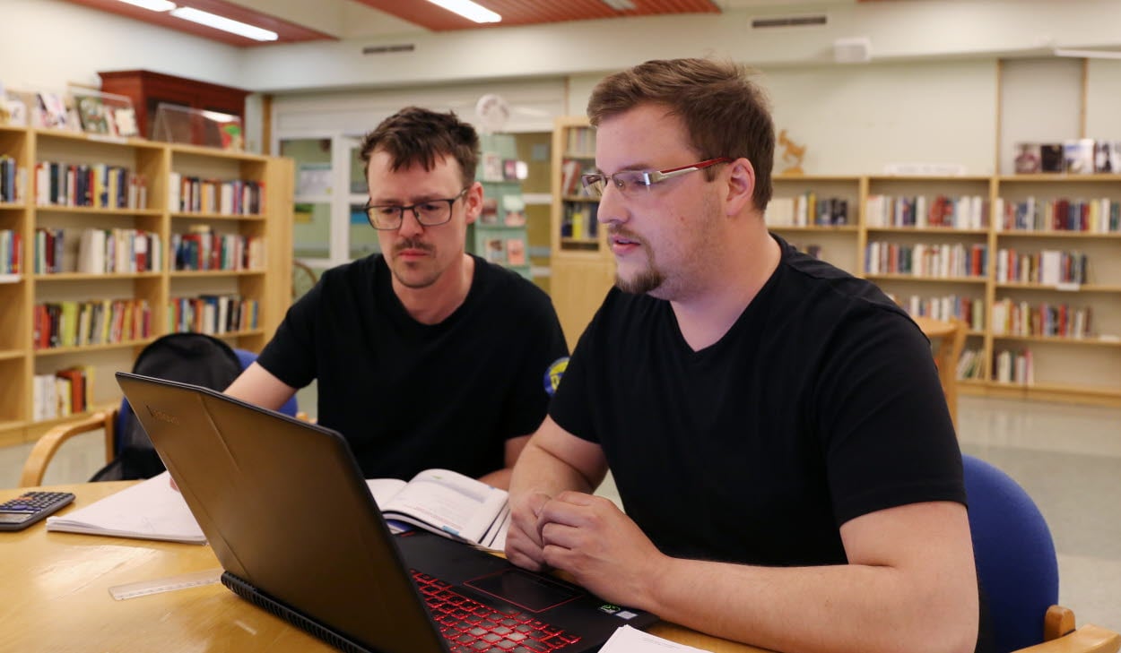 Två kursdeltagare sitter och studerar